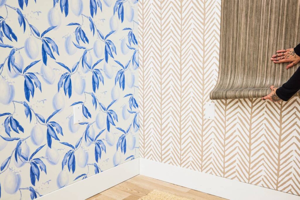 Room corner with contrasting wallpapers featuring blue fruit designs and cream geometric