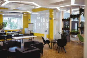 Modern office space with yellow walls, contemporary furniture, and ample natural light.