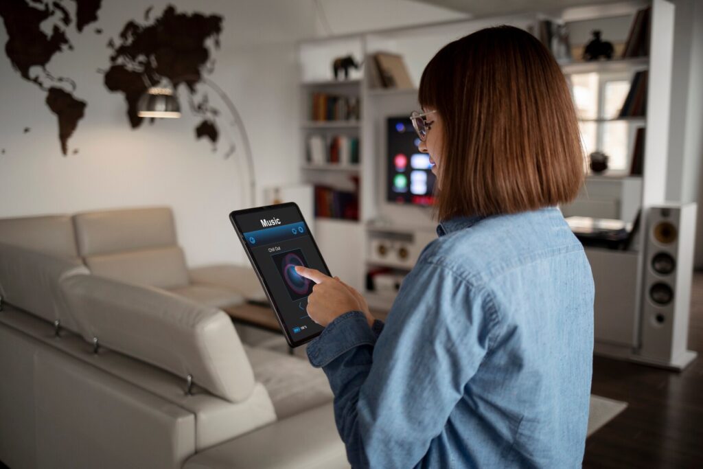 A person in a blue shirt interacts with a tablet displaying a music app, set in a modern living room with a world map mural.