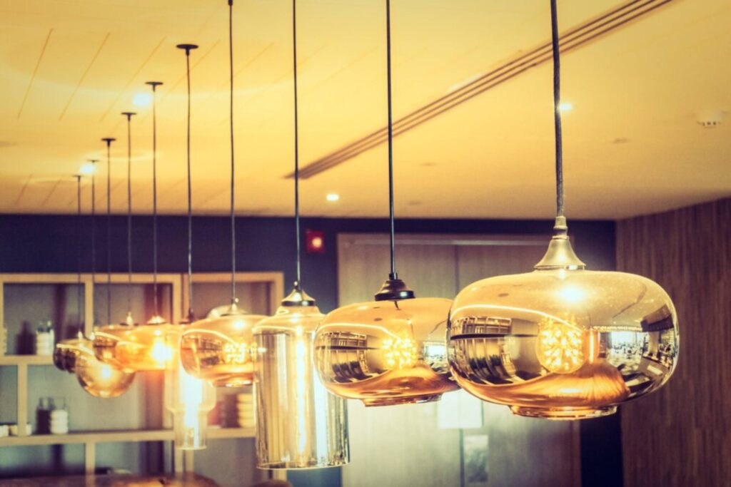 Modern interior with reflective golden pendant lights hanging over a dimly lit room.